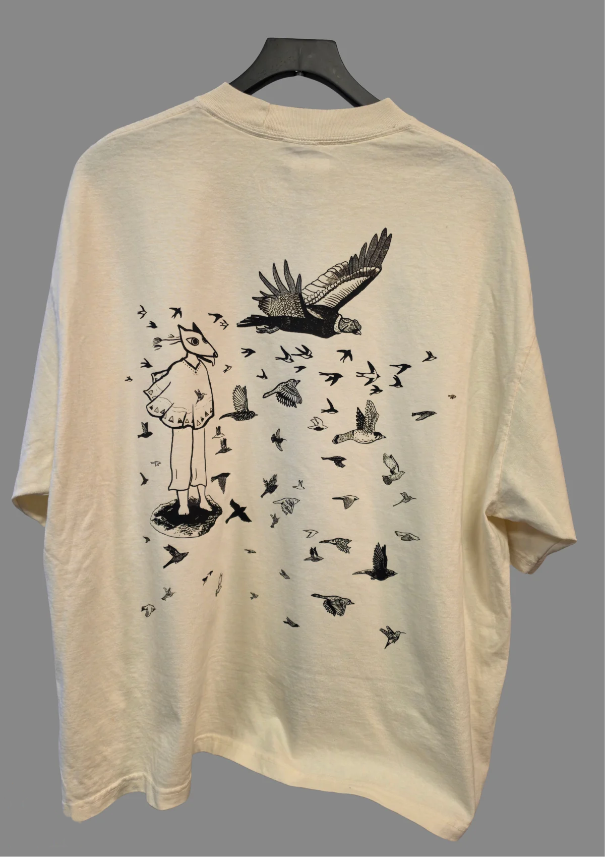 Espalda de una camiseta Cream con los Pájaros de Isaac Orellana a gran tamaño