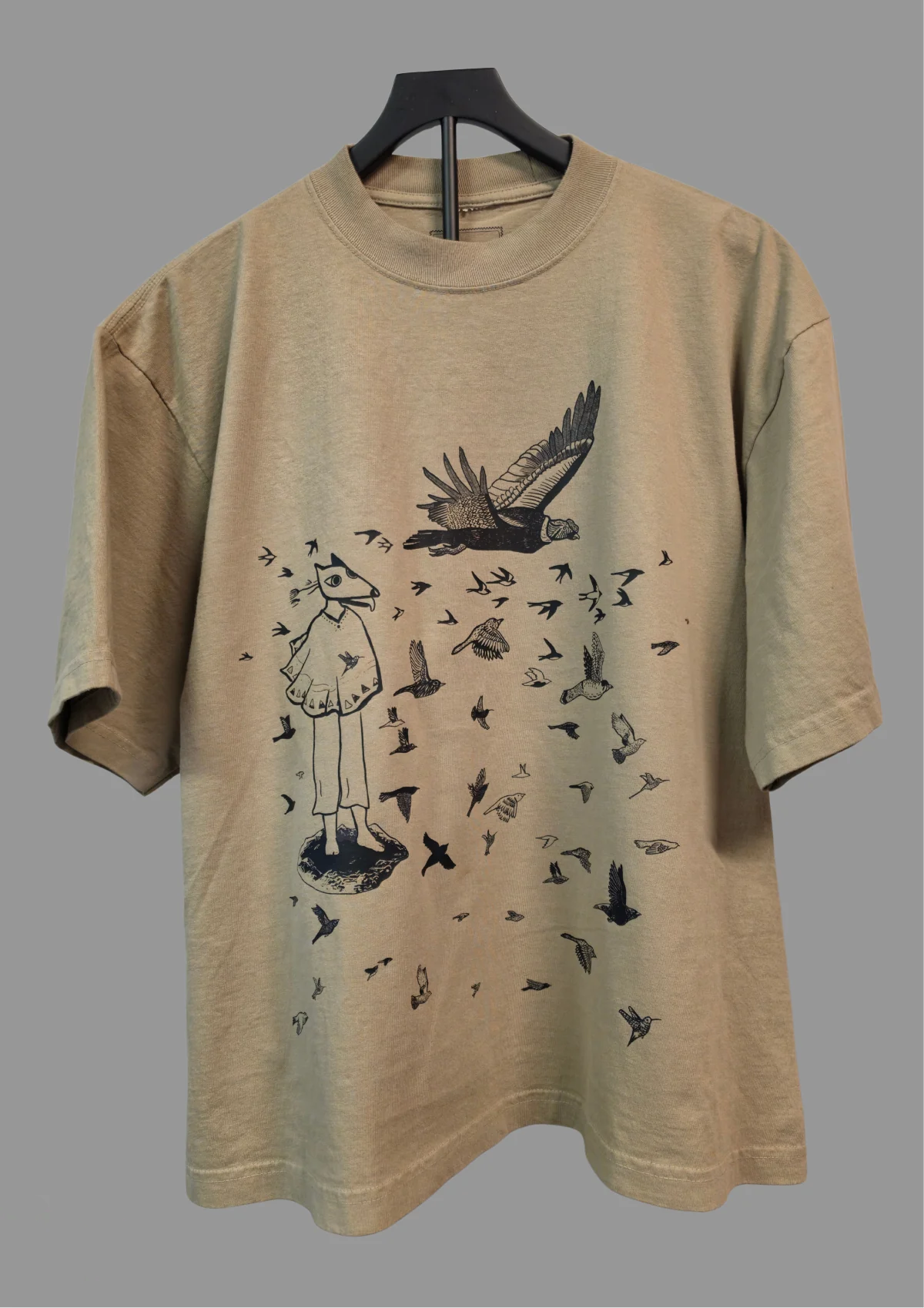 Frente de una camiseta Oatmeal con los Pájaros de Isaac Orellana