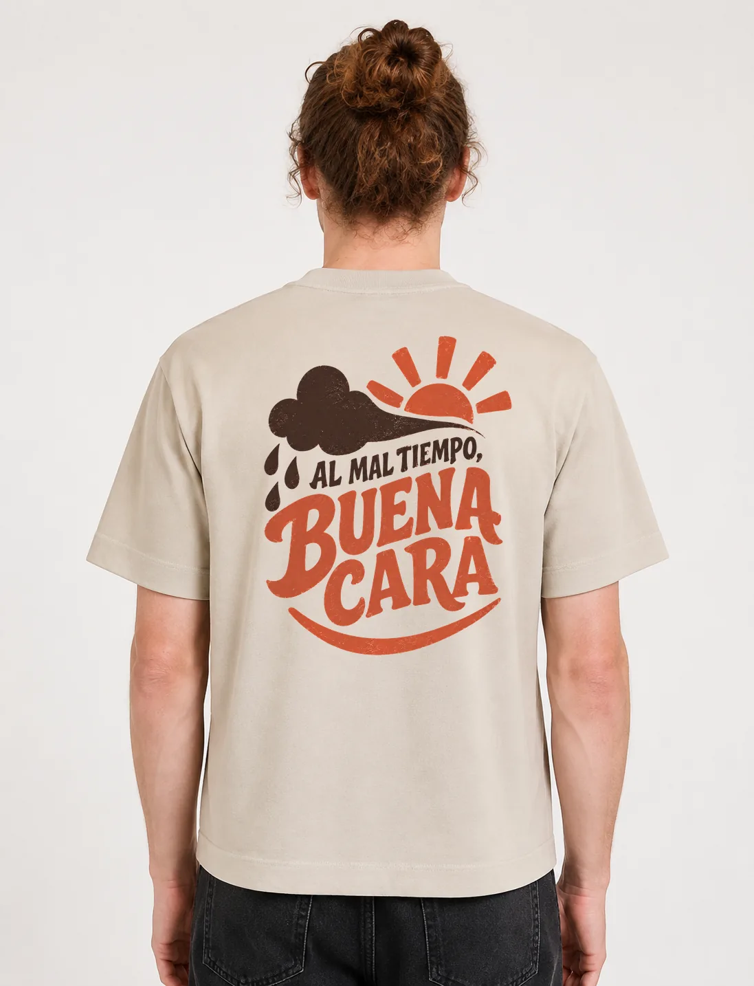 Espalda de una camiseta Cream oversized con el diseño «Al Mal Tiempo, Buena Cara»: una nube de lluvia con gotas junto a un sol con rayos