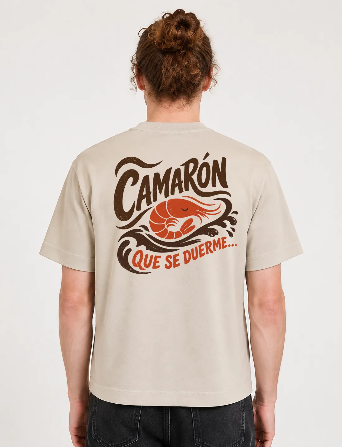 Espalda de una camiseta Cream oversized con el diseño «Camarón Que Se Duerme…»: un camarón dormido flotando sobre el oleaje
