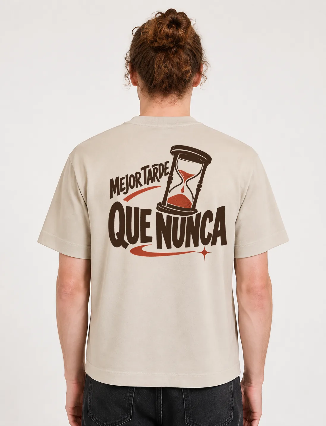 Espalda de una camiseta Cream oversized con el diseño «Mejor Tarde Que Nunca»: un reloj de arena con la arena cayendo