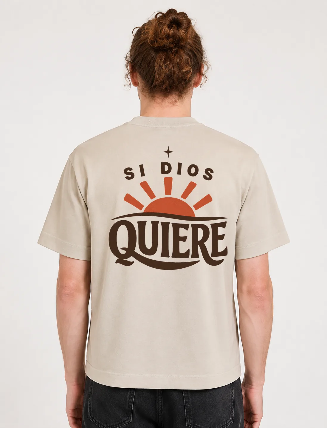 Espalda de una camiseta Cream oversized con el diseño «Si Dios Quiere»: un sol naciente con rayos largos y una estrella