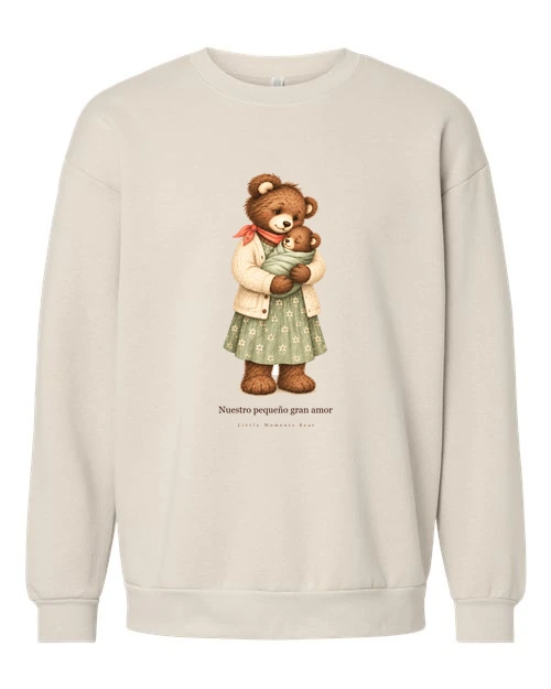 Sudadera Cream con el estampado «Nuestro pequeño gran amor»: una osa con vestido de flores sostiene a un bebé oso envuelto en una manta.